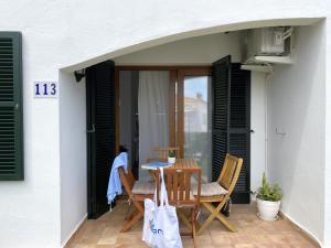 a patio with a table and chairs on a porch at COSTA ARENAL 113 by SOM Menorca in Arenal d'en Castell