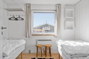 two beds in a room with a window and two stools at 132-Thisted-Sotungevej-31 in Thisted
