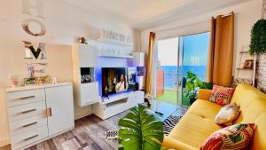 a living room with a yellow couch and a large window at Ocean Soul Apartment in Santa Cruz de Tenerife