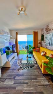 a living room with a yellow couch and a view of the ocean at Ocean Soul Apartment in Santa Cruz de Tenerife