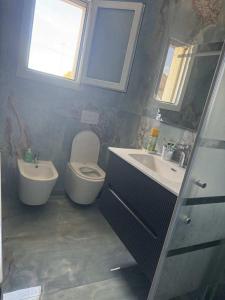 a bathroom with a toilet and a sink and a window at Casa di Nonni in I Forti