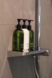 two green bottles are sitting on a shelf in a bathroom at Coconut Bay Eco Resort in Srithanu