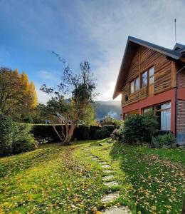 a house with a stone path next to a house at El Portal del Lago in Lago Puelo