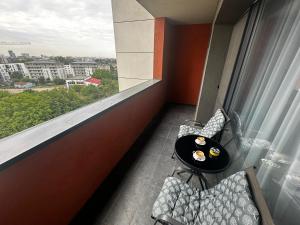 a room with a table and chairs and a large window at Great View & Parking - Harmony Premium Residence in Timişoara