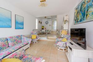 a living room with a couch and a tv at Big Villa Sagaró in S'Agaro