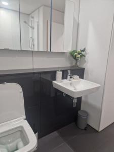 a white bathroom with a sink and a toilet at Ty Branwen- Luxury Woodland Lodge with Stunning Views in Cowbridge +19 photos