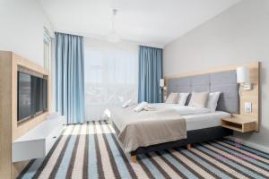 a bedroom with a large bed and a television at Your Holidays Bel Mare 407D in Międzyzdroje