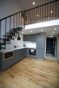 a large kitchen with a staircase in a loft at KgB - 32, Stylish City Apartment - 10 mins walk to Old Town in Vilnius