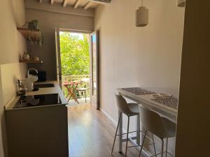 a kitchen with a sink and a counter with stools at Dimora Alberto in Lucca