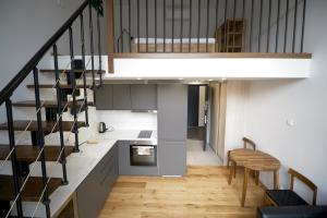 a kitchen with stairs leading up to a loft at KgB - 32, Stylish City Apartment - 10 mins walk to Old Town in Vilnius