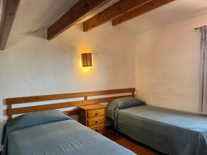 a bedroom with two beds and a light on the wall at MISTRAL 10 by SOM Menorca in Fornells +19 photos