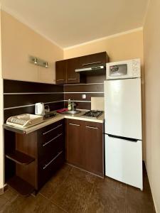 a kitchen with a white refrigerator and a sink at U Gosa in Ustronie Morskie