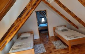 a attic room with two beds and a mirror at Holiday House Visoko by Villas Guide in Brežnica +14 photos