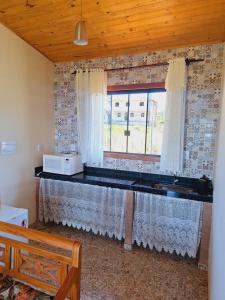 a kitchen with a table with a microwave on it at Luar de Minas suites in Lavras Novas