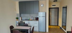a kitchen with a refrigerator and a table and a dining room at Cozy sea view studios in Sozopol