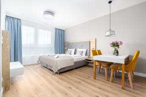 Un dormitorio con una cama, una mesa y un escritorio. en Your Holidays Bel Mare 406 D, en Międzyzdroje