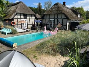 a home with a swimming pool in front of a house at Farm61 badehotellet i det midtjydske - alder +18 år in Tjele