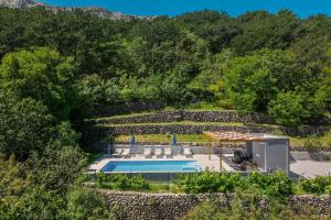 an overhead view of a swimming pool with a stone wall at Apartment Juranić II with pool in Baška
