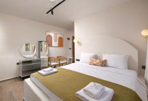 a bedroom with a large bed with two towels on it at Tütsü Suites in Eskiömerler +50 photos