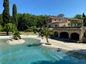 a large swimming pool in front of a house at LA GRANGETTE in Velleron