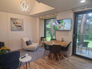a living room with a table and chairs at Ty Branwen- Luxury Woodland Lodge with Stunning Views in Cowbridge
