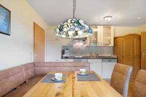 a kitchen and dining room with a wooden table and a chandelier at Waldhuesli Feldberg Gartengeschoss in Feldberg