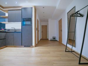 a kitchen with a large refrigerator and a wooden floor at BLACKSTYLE - Stylish Apartment with Balcony & Parking in Tyrol, presented by AlpenLuxus in Brixlegg
