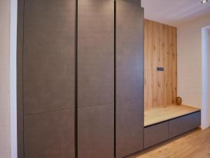 a large metal cabinet with a bench in a room at BLACKSTYLE - AlpenLuxus Collection in Brixlegg