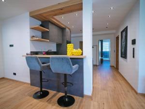 a kitchen with a bar with a blue bar stool at BLACKSTYLE - AlpenLuxus Collection in Brixlegg