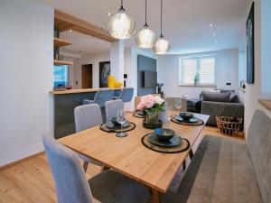 a dining room and living room with a wooden table and chairs at BLACKSTYLE - AlpenLuxus Collection in Brixlegg