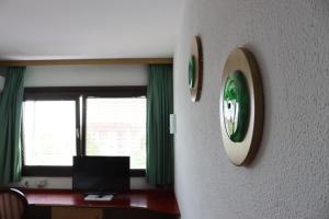 a room with a clock on the wall and a computer at MC Hotel in Žalec