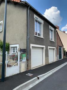 ein Backsteinhaus mit zwei Garagentüren auf einer Straße in der Unterkunft La maison de Leonie 2 chb cour wifi in Châteauroux + 53 Fotos