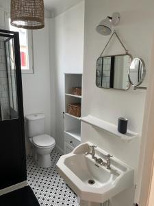 a bathroom with a sink and a toilet and a mirror at La maison de Leonie 2 chb cour wifi in Châteauroux