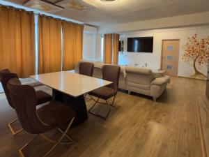 a living room with a table and chairs and a couch at Apartament RYO in Şelimbăr +6 photos
