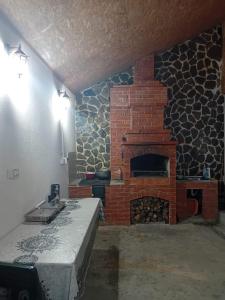 a kitchen with a brick fireplace in a room at Cabana Boema Râușor in Rausor