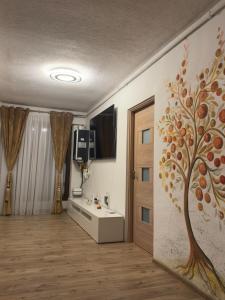 a bathroom with a tree mural on the wall at Apartament RYO in Şelimbăr