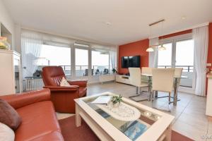 a living room with a couch and a table at Haus "Panorama" Appartement PAN063 in Duhnen