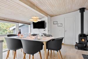 comedor con mesa con sillas y chimenea en 746-Thisted-Blamunkevej-36, en Thisted