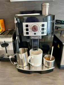 a coffee maker with a cup of coffee on a counter at The Old Post Office Double Room (town centre) in Carnoustie +18 photos