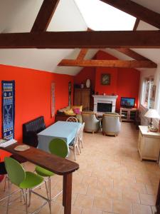 a living room with red walls and a table and chairs at Beaux retours in Dives-sur-Mer