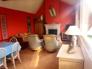 a living room with red walls and a table and chairs at Beaux retours in Dives-sur-Mer
