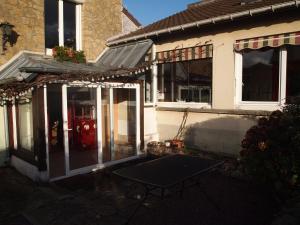 a house with a red door and a table outside at Beaux retours in Dives-sur-Mer