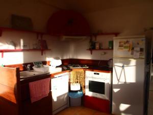 a kitchen with a white refrigerator and a stove at Beaux retours in Dives-sur-Mer +2 photos
