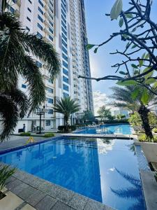 a large swimming pool with palm trees and buildings at The Monroe at Horizons 101 in Cebu City