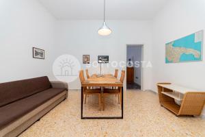 un soggiorno con un tavolo e un divano di La Casina Di Mare a Porto Cesareo Altre 31 foto