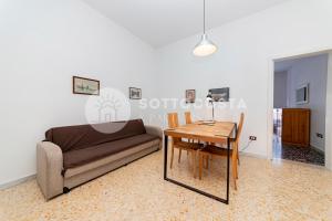 un soggiorno con un divano e un tavolo di La Casina Di Mare a Porto Cesareo