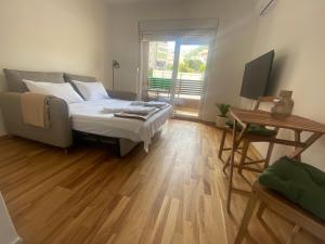 a bedroom with a bed and a television in it at Stylish Studio IVSOLE in Budva