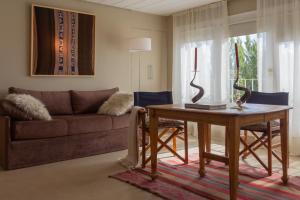 a living room with a table and a couch at Los Ponchos Hotel in El Calafate