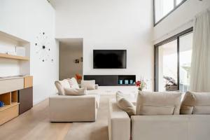 un soggiorno bianco con divano e sedie bianchi di Camiral Golf and Wellness Luxury Villa a Girona