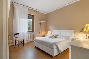 a bedroom with a bed and a chair and a window at Il nido Emozioni charme e colori in Fiesole